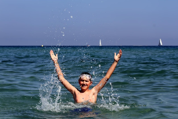 Actieve jongen die in het zeewater zwemt.