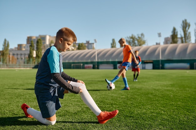 Actieve kinderen voetballen op groen sportveld buiten