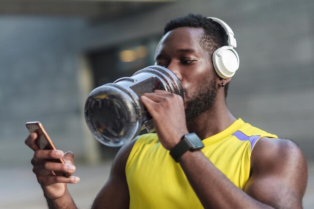 Actieve levensstijl sterke Afrikaanse man drinkwater na zware training