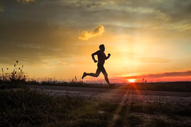 Actieve man silhouet uitgevoerd bij zonsondergang