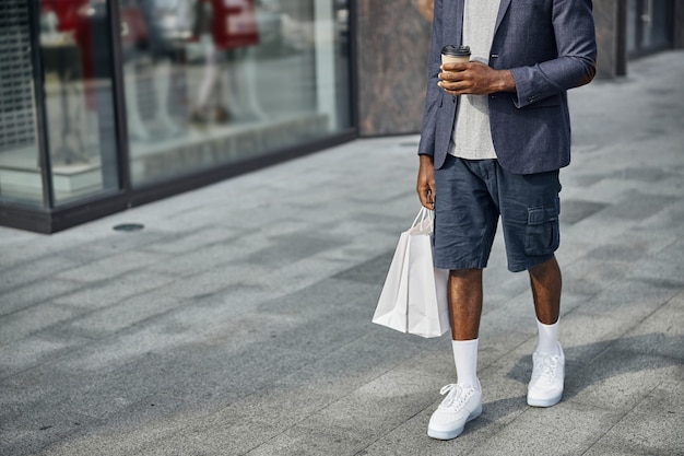 Actieve mannelijke persoon die gezellige kleding draagt tijdens een winkeldag in het stadscentrum