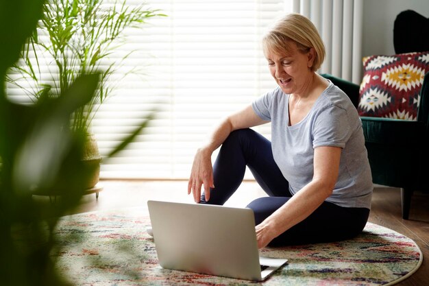 Foto actieve oudere vrouw die een computer gebruikt