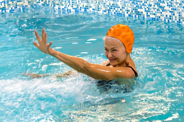 Actieve oudere vrouw die graag aqua-aerobics doet in het zwembad