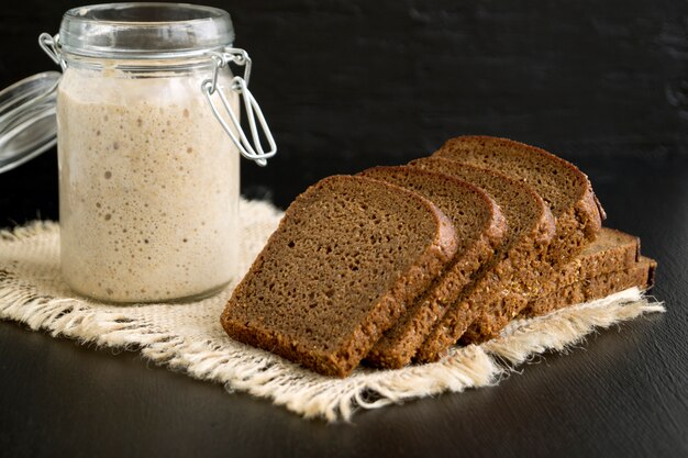 Actieve roggezuurdesem in een glazen pot voor zelfgebakken brood.