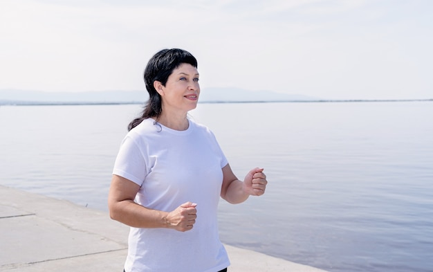 Actieve senior vrouw joggen in de buurt van de rivier