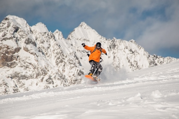 Actieve snowboarder die op de berghelling berijdt