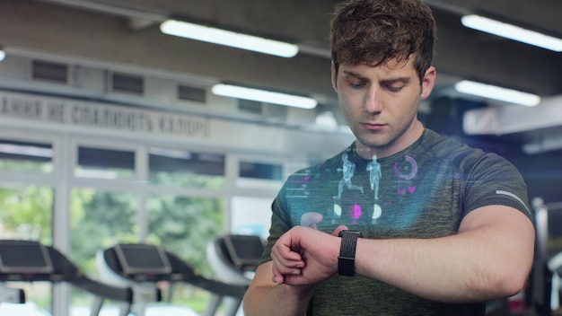 Actieve sportman in de sportschool controleert gezondheidsindicator en hartslag op smartwatch Toekomstige technologie concept van de mensheid 3D render animatie
