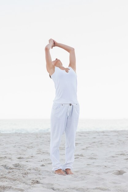 Actieve vrouw het praktizeren yoga op het strand