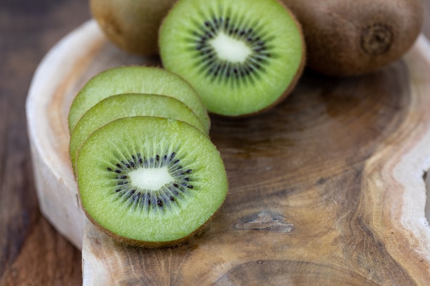 Photo actinidia chinensis pieces on wooden cutting board.