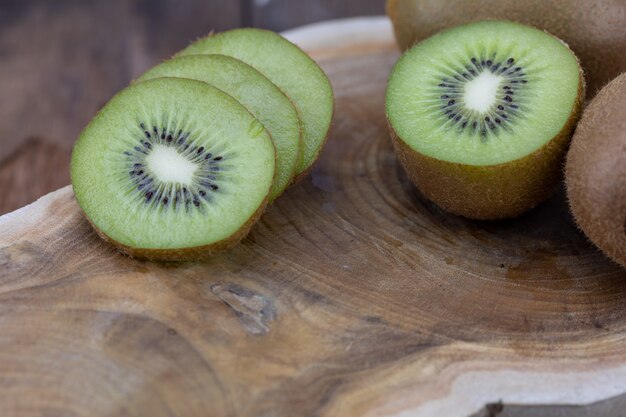 Photo actinidia chinensis pieces on wooden cutting board.