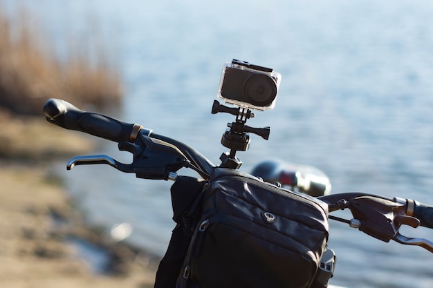 강을 배경으로 방수 케이스에 자전거 포장 가방이있는 자전거의 액션 카메라.
