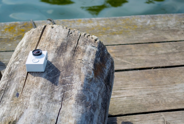 Action camera lying on the surface of the old log