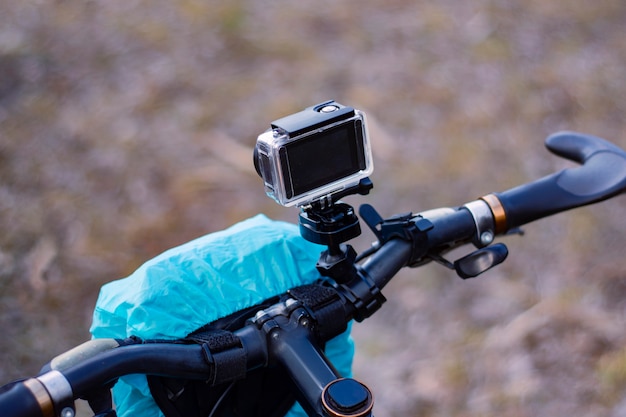 Action Camera op een fiets met een fietstas in een waterdichte koffer tegen de achtergrond van de natuur.