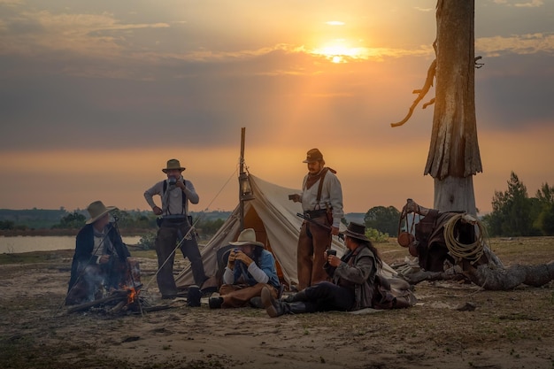 Action image vintage style of the cowboy group Sit back and relax and have coffee in the morning camping in the golden light of the morning sun