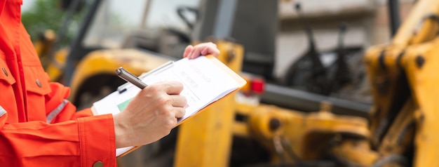 Action of safety officer is writing on safety checklist document during safety audit and inspection