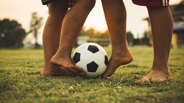 action sport outdoors of a group of kids having fun playing soccer football.