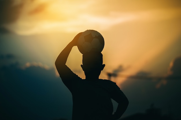 Un'immagine di sport di azione del bambino che gioca a calcio di calcio per l'esercizio nella comunità sotto il