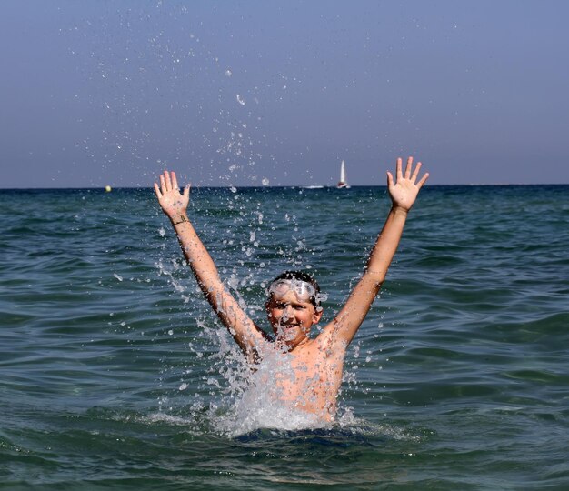 Active boy playing with sea water.