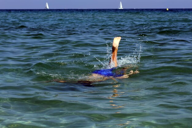 Active boy swimming in the sea water.