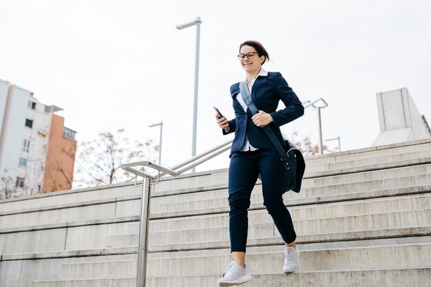 Active businesswoman moving downstairs in the city