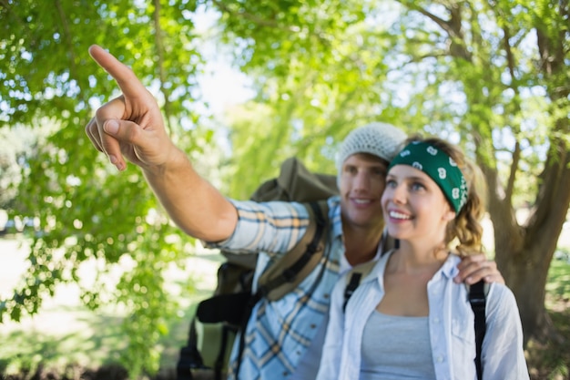 Active couple on a hike with man pointing