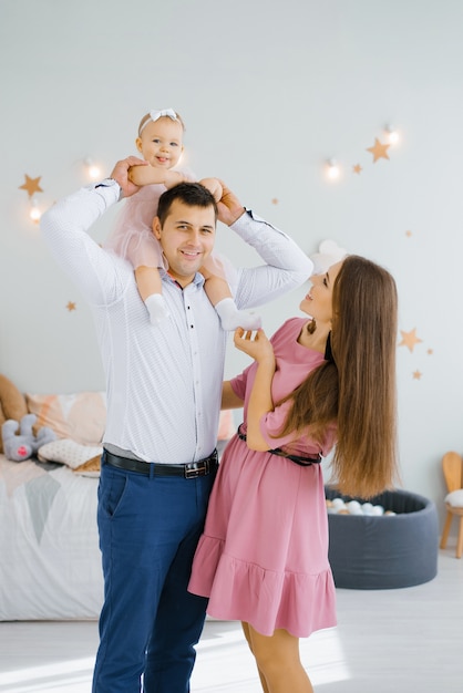 Active daughter sits on the father's neck.