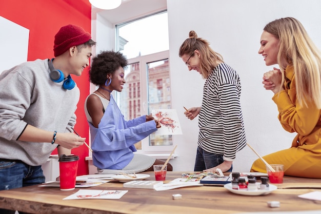 Discussione attiva. quattro begli studenti intelligenti del dipartimento di moda che discutono attivamente