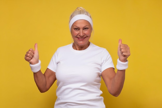 Active elderly woman holding her thumb up