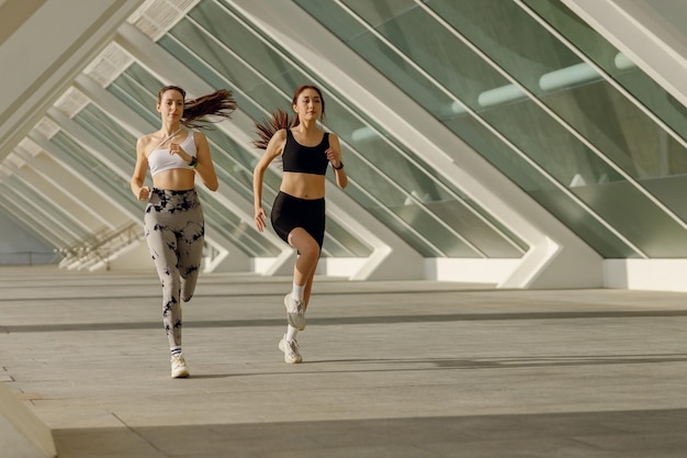 Photo active female friends in sportswear running outdoors on a sunny day morning jog