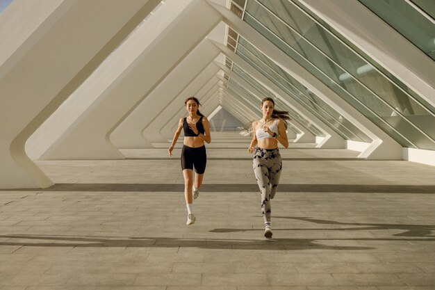 Photo active female friends in sportswear running outdoors on a sunny day morning jog