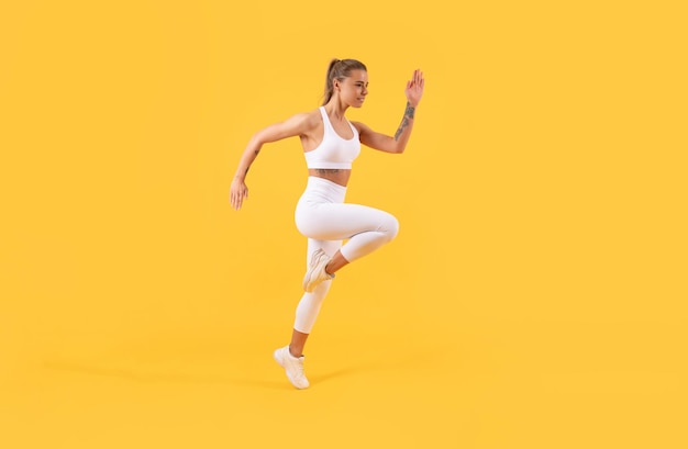 Photo active fitness girl runner running on yellow background