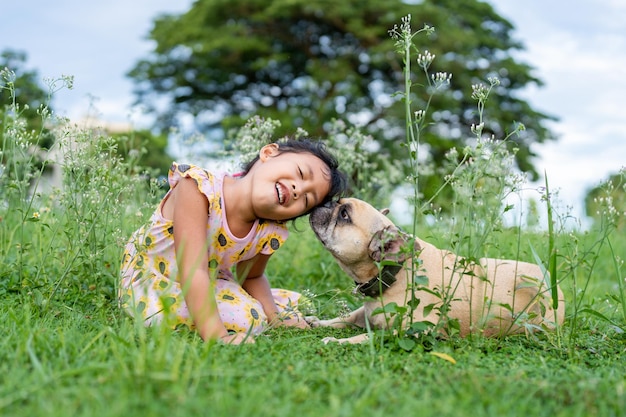 草原で犬と遊ぶアクティブな女の子。