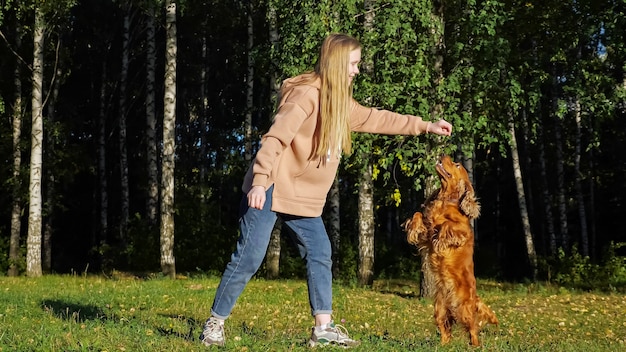 Active girl with long loose fair hair plays with funny dog