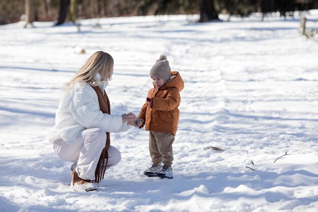 Foto una madre attiva e felice cammina lungo un sentiero nella foresta invernale insieme ai suoi figli piccoli vacanze familiari invernali felice maternità