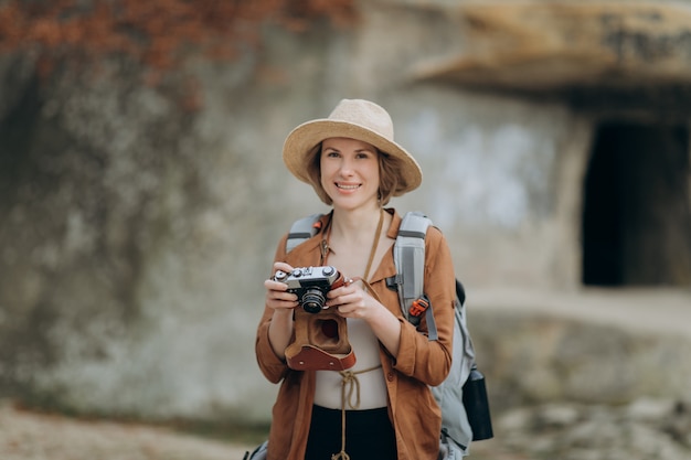 사진 숲 바위에 빈티지 필름 카메라로 사진을 찍고 활성 건강한 백인 여자