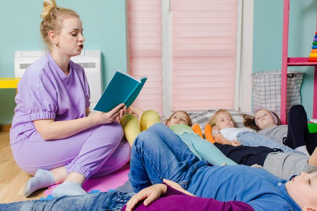 Active kids laying on soft pillows and mats at the kindergarten