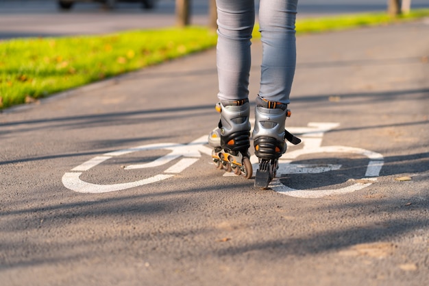 Tempo libero attivo. una ragazza sportiva è rollerblade in un parco in autunno.