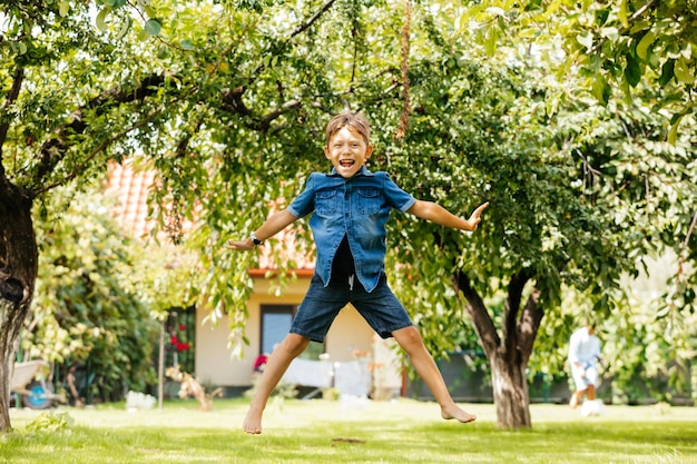 アクティブな男の子は裏庭で楽しんでいます