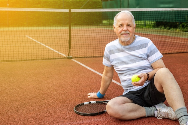 Photo an active pensioner man playing tennis outside, enjoying lovely summer day