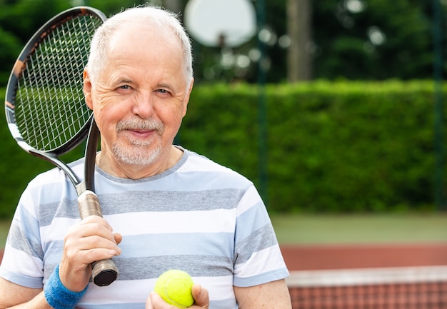 Un pensionato attivo, ritratto di un uomo anziano che gioca a tennis in esterno, sport in pensione, concetto di sport