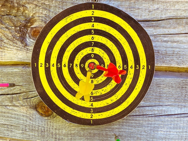 Foto gioco attivo lanciando freccette freccette campo rotondo all'aperto con freccette nere e gialle