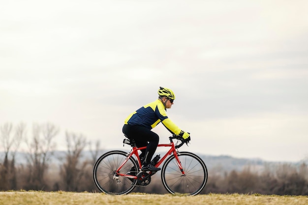 An active senior bicyclist rides a bike in nature