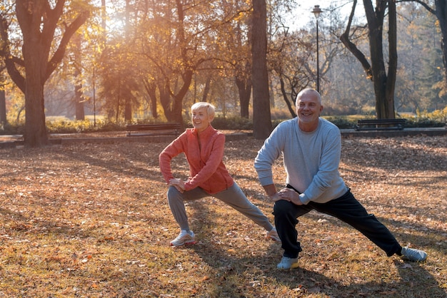 Coppia senior attiva che si esercita all'aperto nel parco in una bella giornata di sole