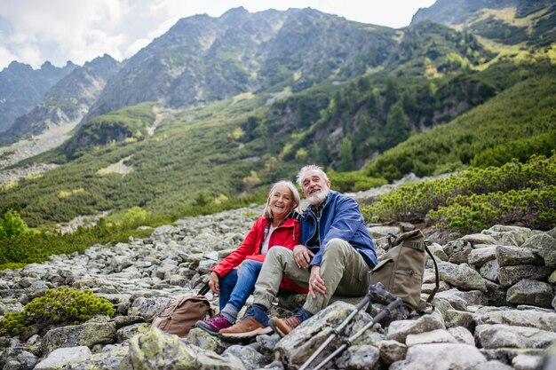 Active senior couple hiking together in autumn mountains