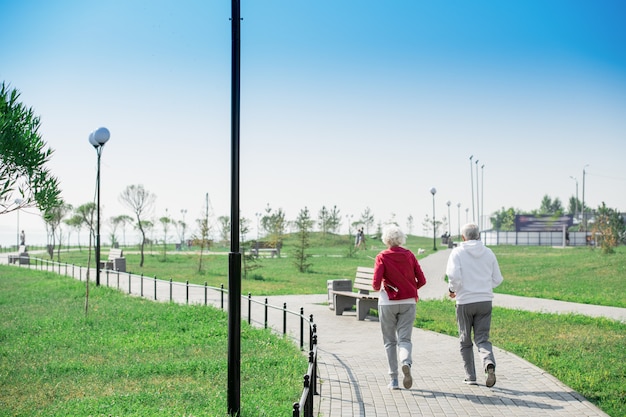 Active Senior Couple Running in park Back View