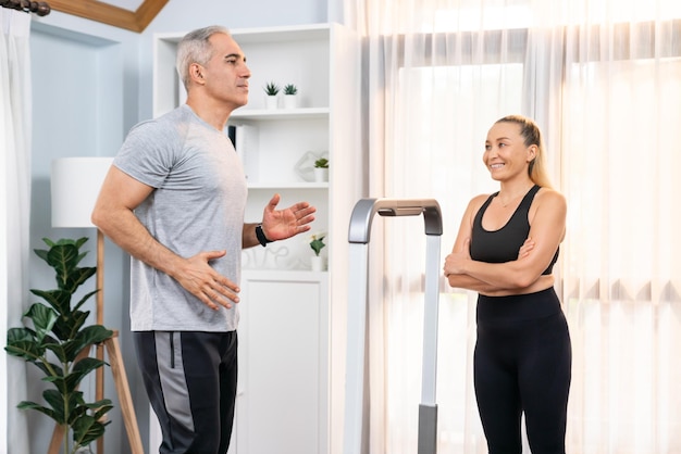 Active senior couple running on tread running machine at home together as fitness healthy lifestyle and body care after retirement for pensioner Clout