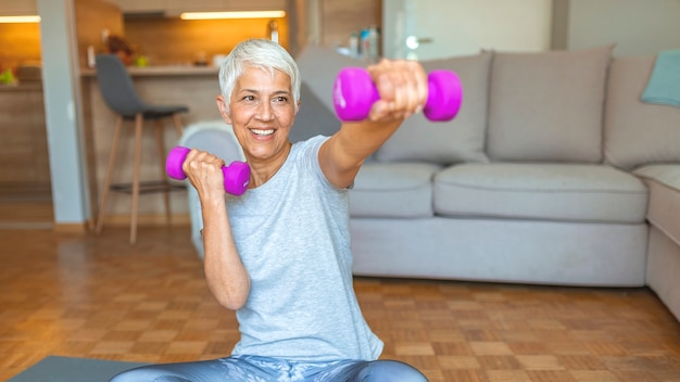 Active senior woman at home exercising with weights. mature woman exercise at home.