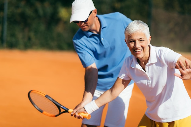 Active Senior Woman Practicing Tennis