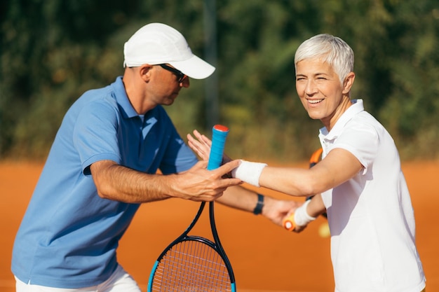 Active Senior Woman Practicing Tennis