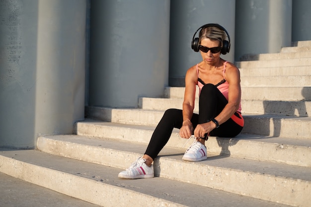 La donna anziana attiva inizia l'allenamento fitness in città